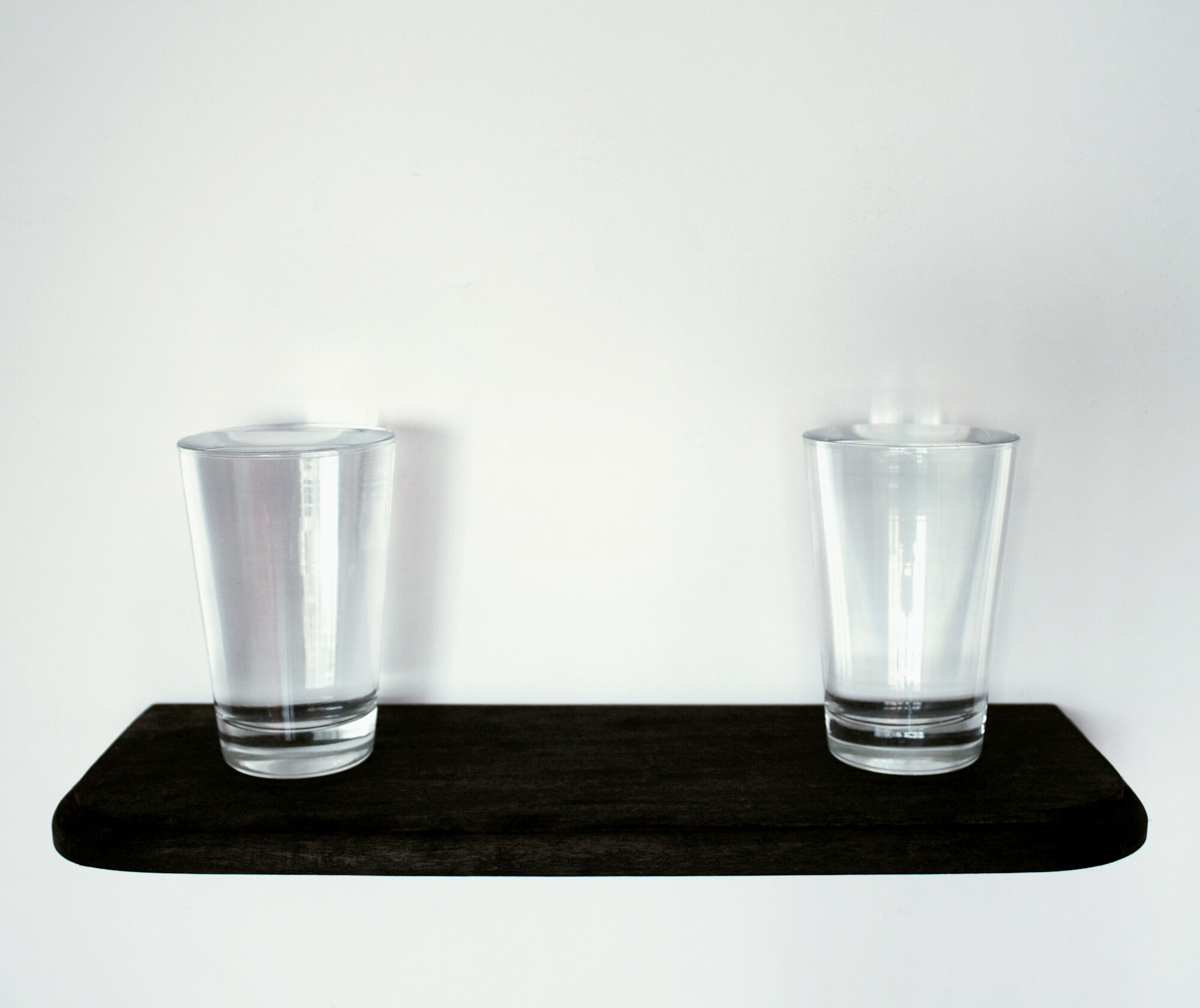 Deyson Gilbert. T&iacute;tulo: Copo com &Aacute;gua Benta ao Lado de Copo com &Aacute;gua Comum. T&eacute;cnica: Dois copos de vidro, prateleira de madeira, &aacute;gua benta e &aacute;gua comum Ano: 2010 Dimens&otilde;es: 16 x 40 x 16 cm Edi&ccedil;&atilde;o: 3/3 + 1AP